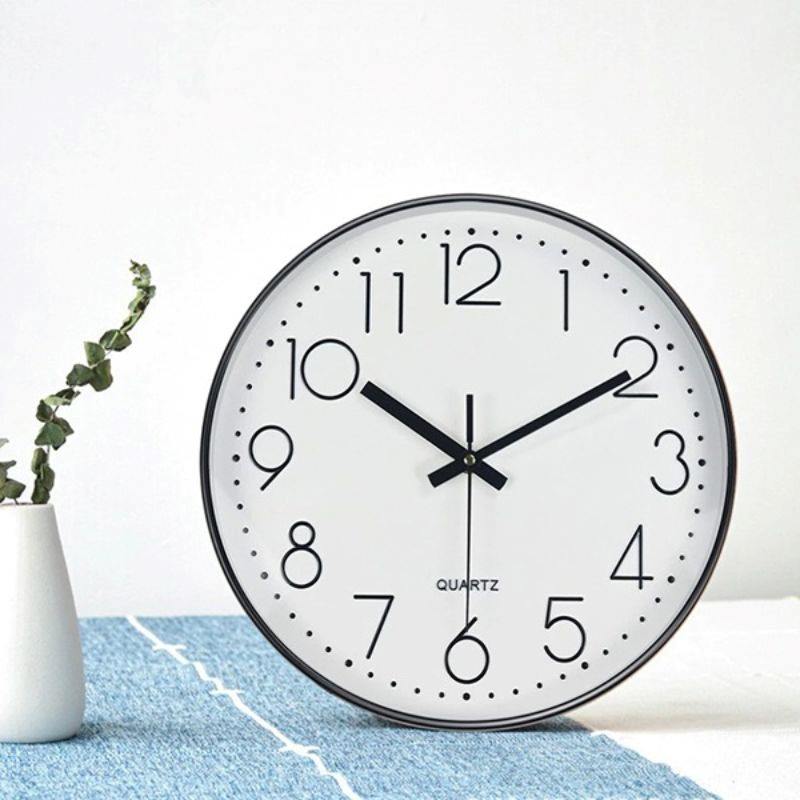 Đồng hồ vành kim loại đen mảnh mai cho căn hộ hiện đại.